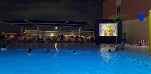 Audience watching movie from outdoor pool