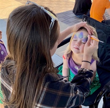 Little girl waits patiently as the artist finishes