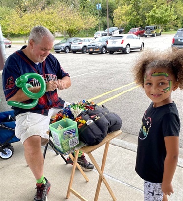 Balloon artist with littel girl