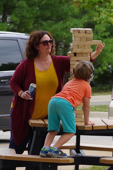 A mom and young boy play Jenga