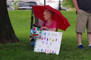 a spectator with a sign rooting on their runner