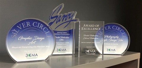 four awards, two are round in a blue color, one is clear crystal and one is blue with the word Savvy on top.