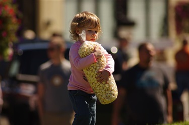 Little girl hugging a large back of kettlecorn