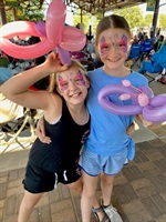 Two young girls with faces painted like butterfulies