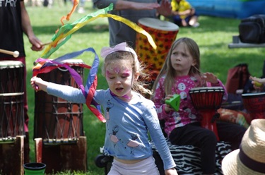 a young girl dancing with ribbons to drum music
