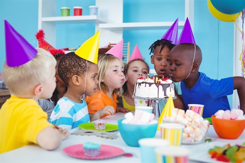 Children wearing party hats at table