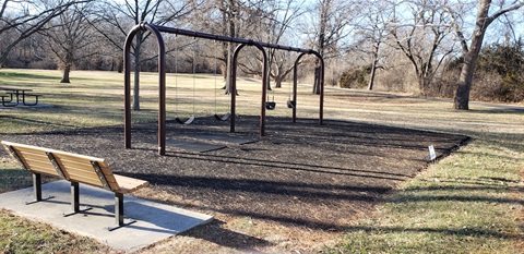Four empty swings at Chatlain Park. Mulch rests underneath the  swings.