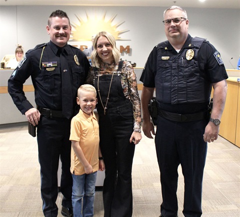 Sgt. Chris Meyer stands with his family and the police chief in front of the City Council Chambers.