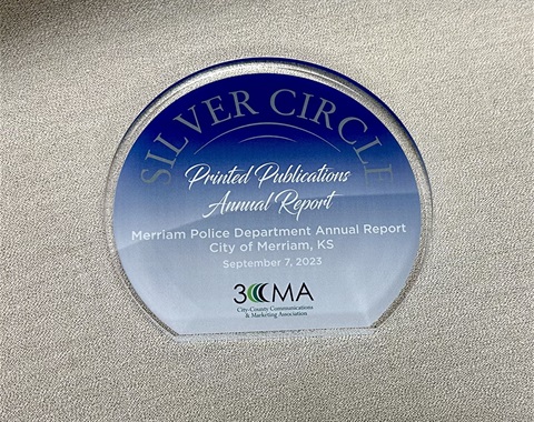 A blue and glass award that says Silver Circle Printed Publication Annual Report.