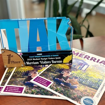 TIAK Award trophy on top of the 2024 Merriam visitor guide