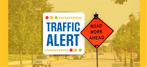 Traffic Alert and construction work signs with downtown Merriam in the background.