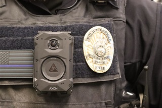 A Body Camera and a Merriam police badge.