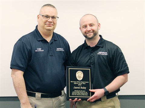 Police Det. Jared Ruby on right holding a plaque and standing next to Merriam Police Chief Darren McLaughlin.