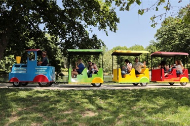 a side view of the trackless train with waving passengers