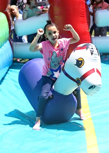 a young girl bouncing to victory on an inflatable horse