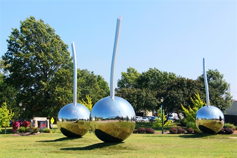 Three reflective seedling sculptures adorn the lawn at Merriam Marketplace. 