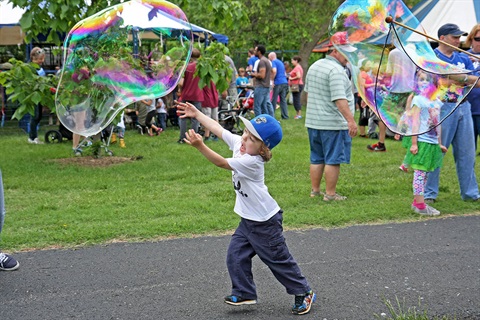 Kid playing with bubbles at Turkey Creek Festival